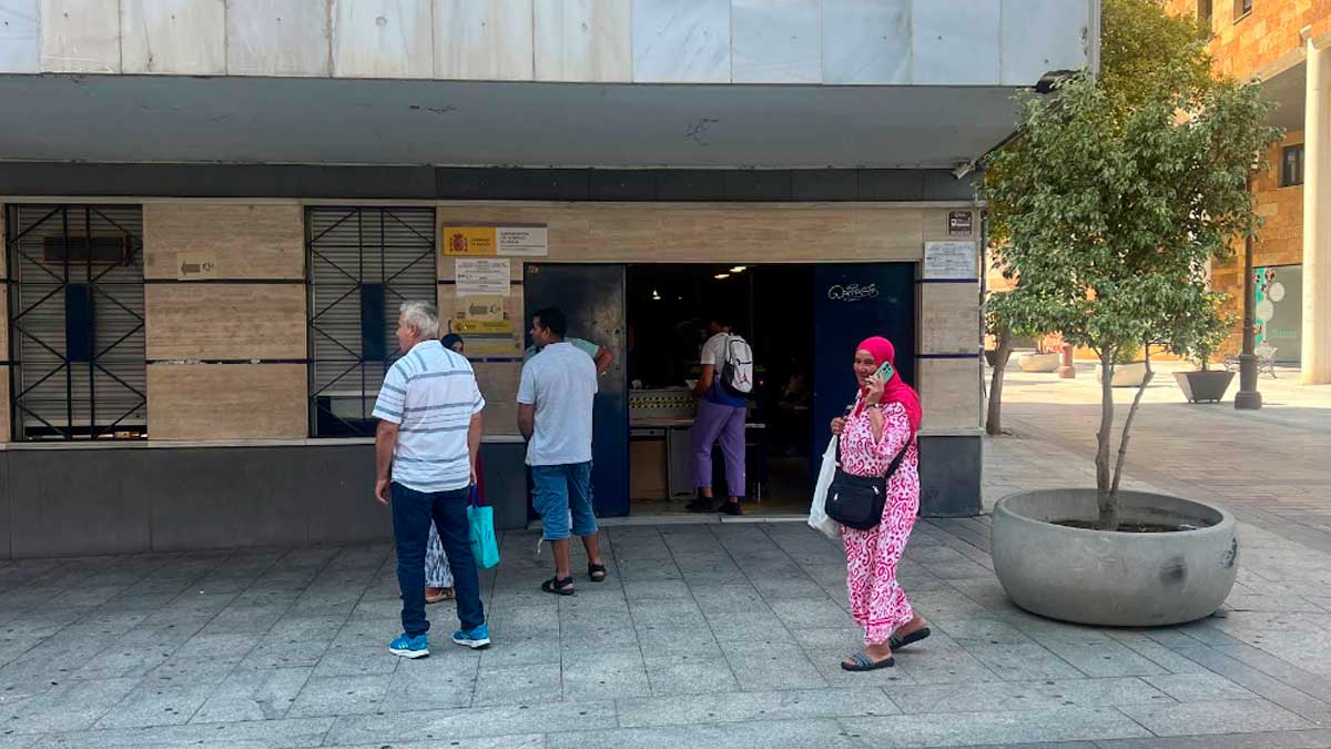 Personas esperan en la entrada de la Oficina de Extranjería de Huelva ante la nueva regularización