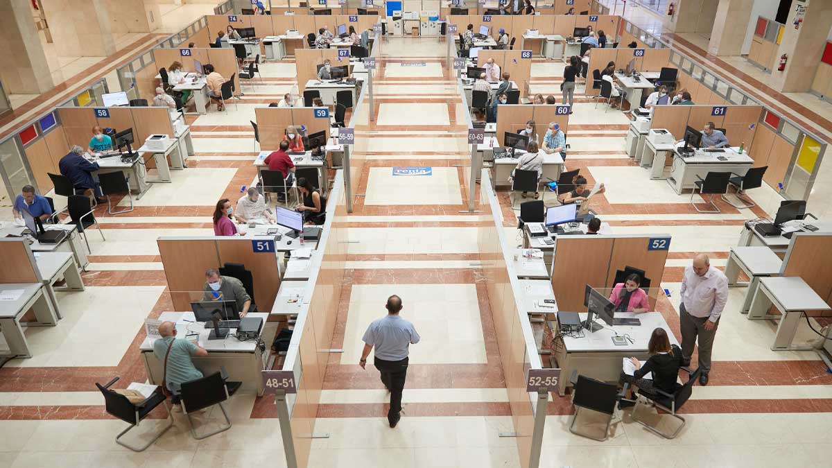 Oficina de la Agencia Tributaria con contribuyentes realizando gestiones de la renta y novedades fiscales en España