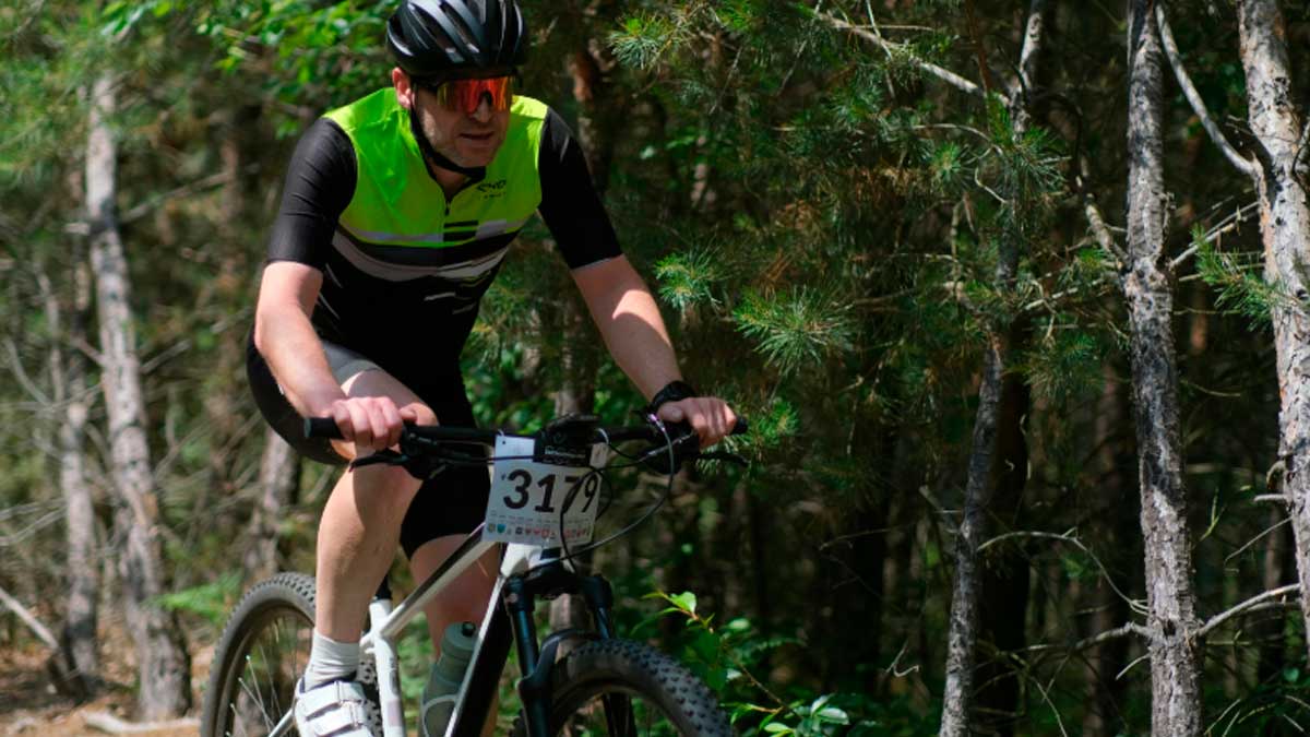 Ciclista en carrera de bici de montaña durante una competición en el bosque mientras estaba de baja médica