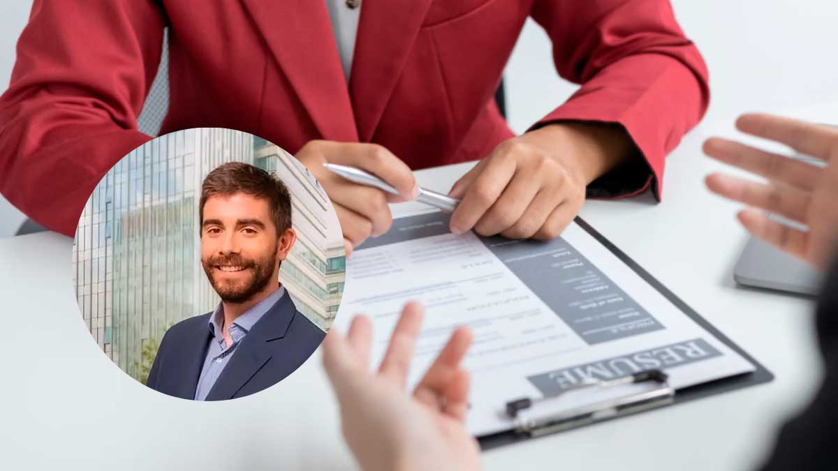 Entrevista de trabajo con reclutador revisando currículum y candidato respondiendo preguntas