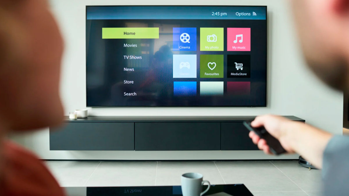 Smart TV mostrando su menú mientras un usuario usa el mando a distancia en el salón