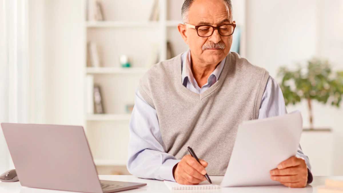 Hombre revisando documentos sobre su pensión de jubilación tras periodos sin cotizar