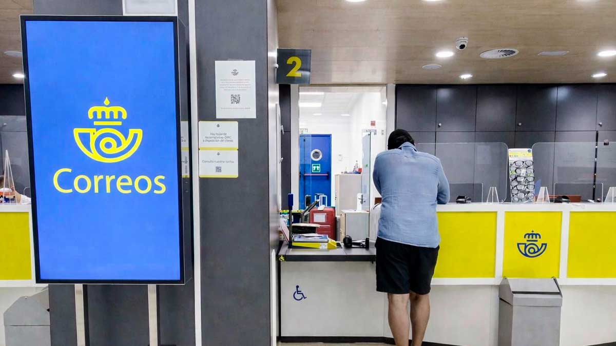 Oficina de Correos con ventanillas de atención al público para trámites de regularización de migrantes en España