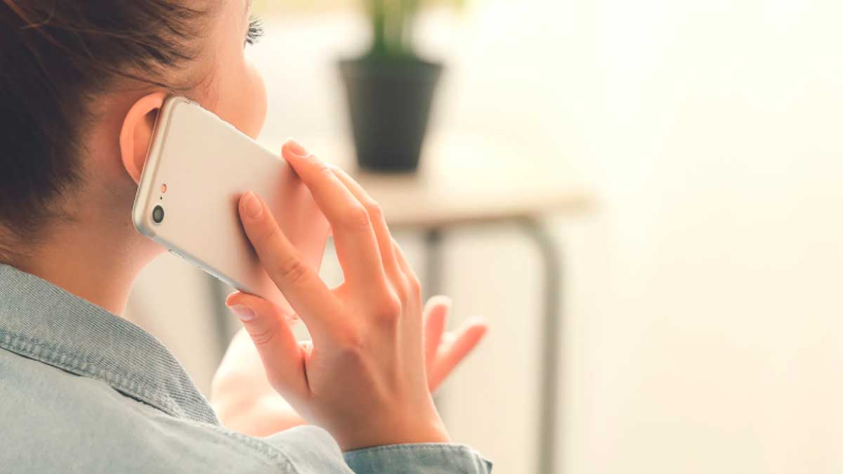 Mujer atendiendo llamada comercial en móvil con nuevo prefijo 400 en España