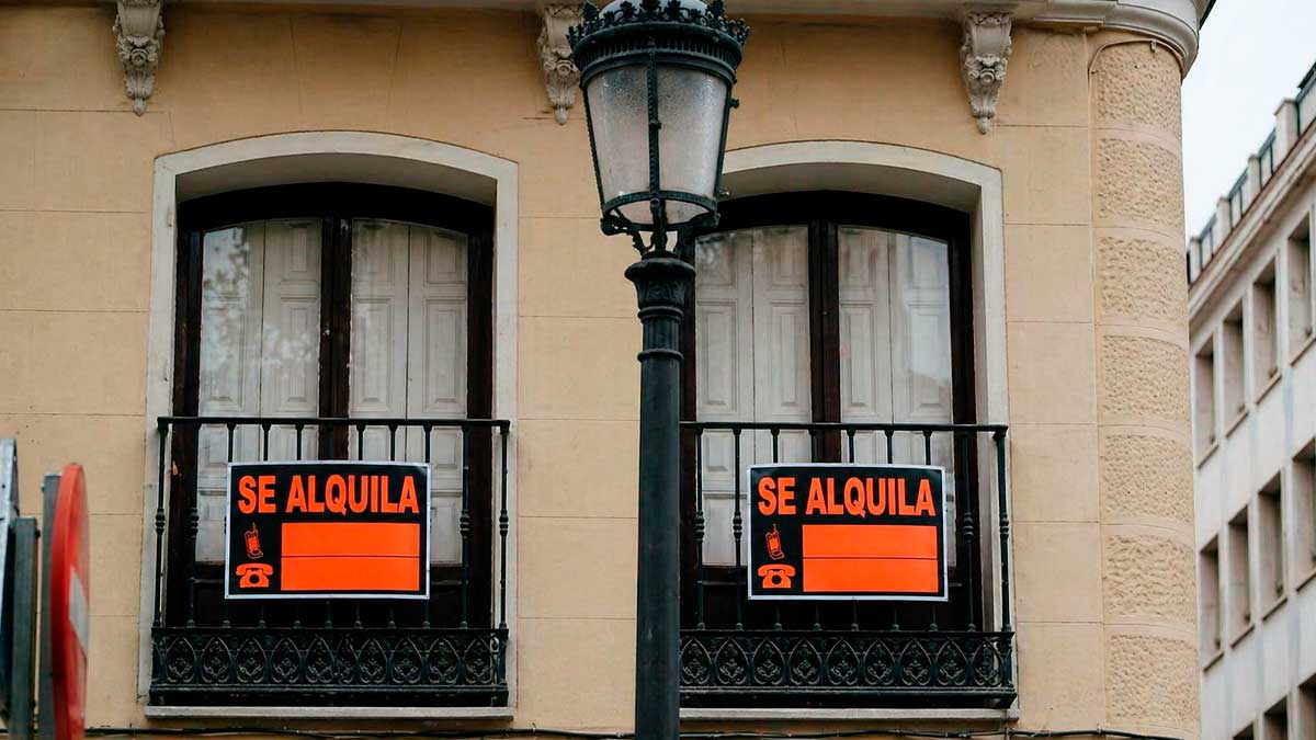 Dos balcones con carteles de se alquila en edificio urbano en Andalucía reflejando el aumento del alquiler