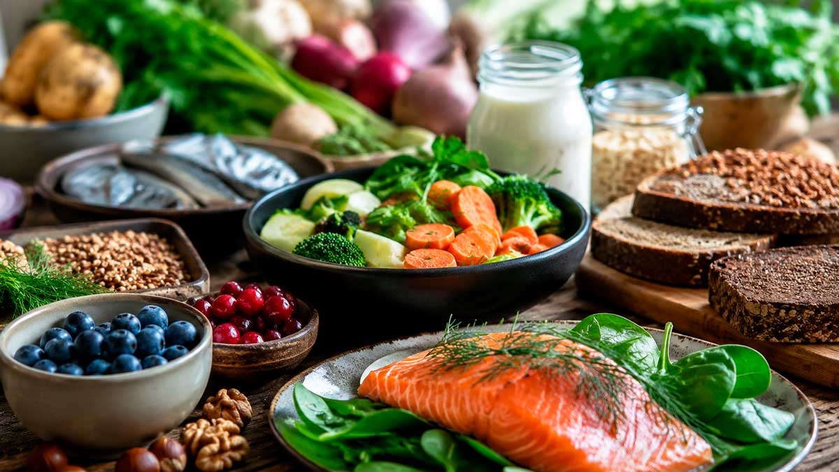 Alimentos de la dieta nórdica con salmón, frutos rojos, verduras y cereales integrales