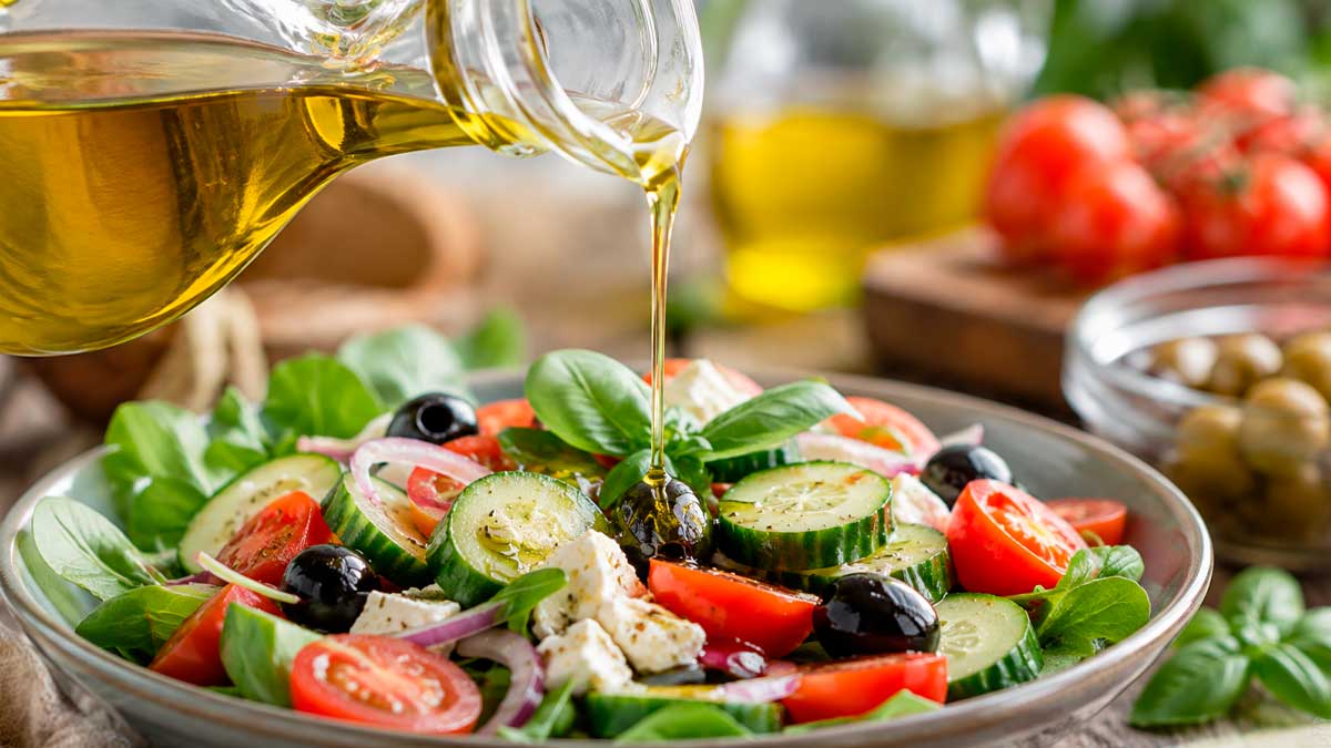 Aceite de oliva virgen extra servido en crudo sobre una ensalada mediterránea.