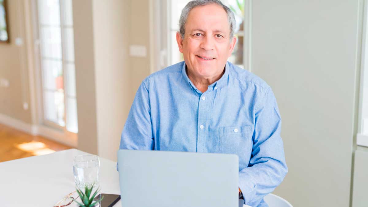 Hombre mayor de 45 años trabajando en ordenador, empleo para mayores en Andalucía