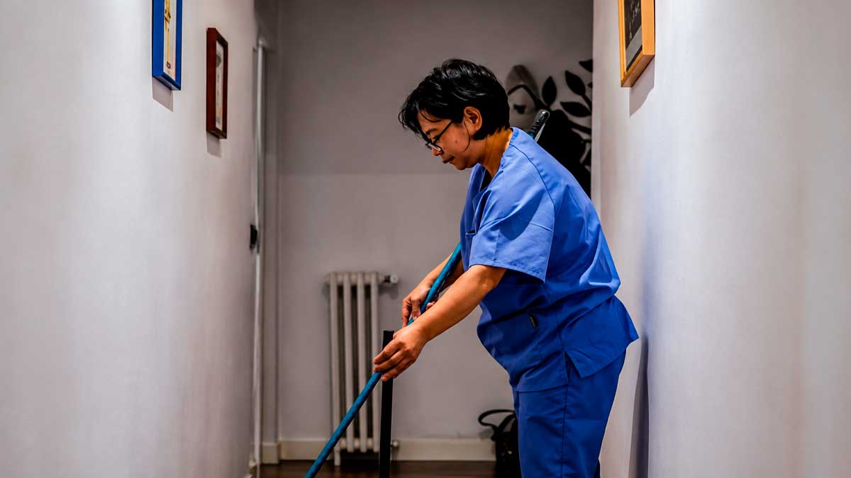 Empleada del hogar limpiando un pasillo, paro de empleadas del hogar